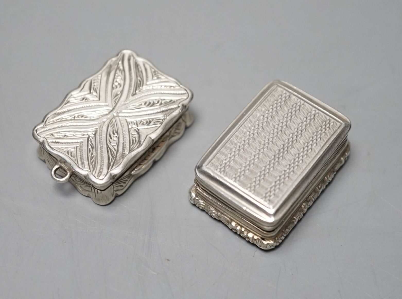 A George IV engine turned silver rectangular vinaigrette, Thomas & William Simpson, Birmingham, 1823, 30mm and a later silver vinaigrette by George Unite, Birmingham, 1866, engraved with the name 'Emmie', 29mm.